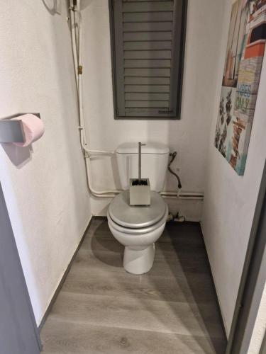 une salle de bain avec des toilettes blanches dans une chambre dans l'établissement A 35 pas de l'Eau, à Canet
