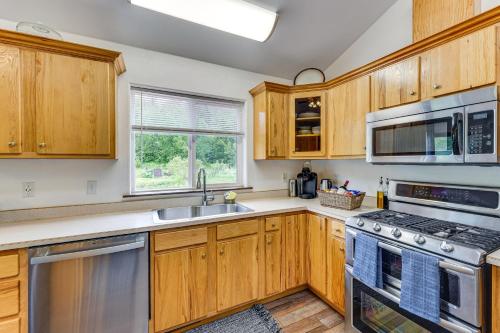 a kitchen with wooden cabinets and stainless steel appliances at Palmer Escape with Mtn Views Fishing and Hiking! in Palmer