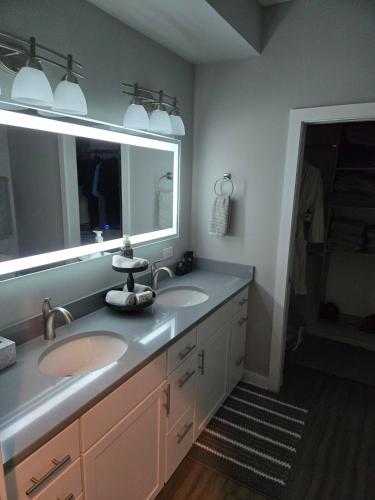 a bathroom with two sinks and a large mirror at Welcome to Luigi! in Omaha