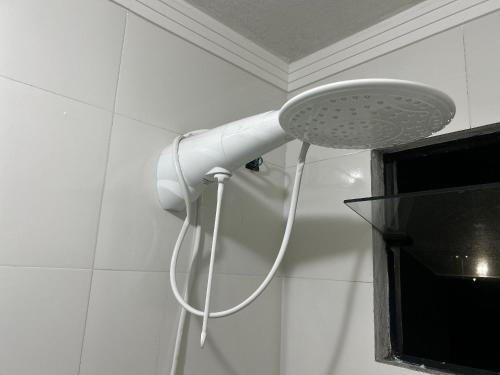 a shower with a white shower head in a bathroom at Apartamento Aconchegante Central (Borboleta) in Itajaí