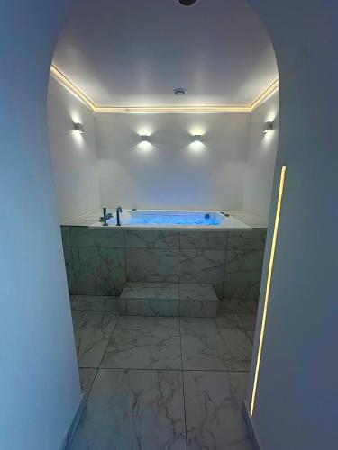 La salle de bains est pourvue d'une baignoire bleue. dans l'établissement TheFloor Hotel - Suite Prestige, à Coignières