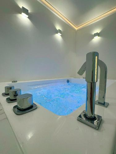 La salle de bains est pourvue d'une baignoire avec de l'eau bleue. dans l'établissement TheFloor Hotel - Suite Prestige, à Coignières