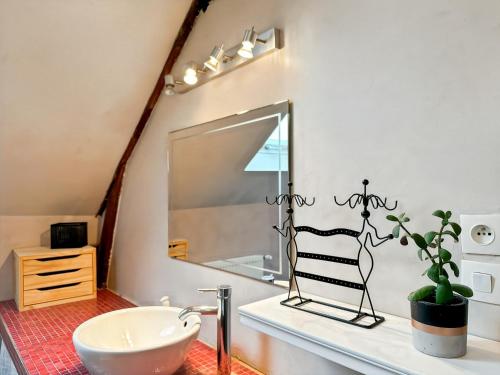 une salle de bain avec un lavabo et un miroir dans l'établissement L'Evasion - Villa Proche Rennes - Calme - Jardin, à Vern-sur-Seiche