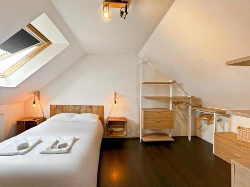- une chambre mansardée avec un lit et une étagère dans l'établissement L'Evasion - Villa Proche Rennes - Calme - Jardin, à Vern-sur-Seiche