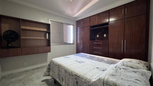 a bedroom with wooden cabinets and a large bed at Confortável apartamento in Jataí