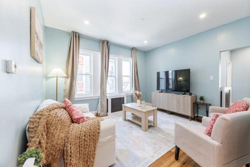 a living room with two couches and a tv at Stylish 3 Bedroom Apartment in Boston