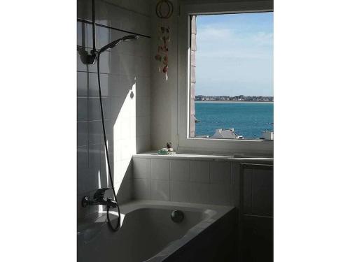 une salle de bain avec une baignoire et une fenêtre dans l'établissement Holiday apartment with 3 bedrooms, à Sibiril