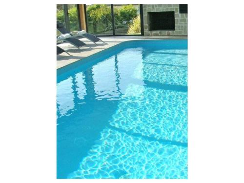 - une piscine avec 2 chaises et de l'eau bleue dans l'établissement Holiday apartment with 3 bedrooms, à Sibiril