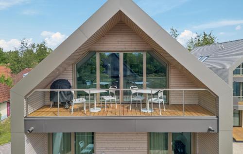 ein Haus mit einem Balkon mit einem Tisch und Stühlen in der Unterkunft 2 Bedroom Gorgeous Apartment In Tossens in Stick