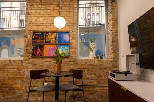 a brick wall with a table and two chairs at 3 Private King Suites - The Finnley Hotel in Grand Rapids