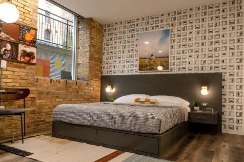 a bedroom with a bed and a brick wall at 3 Private King Suites - The Finnley Hotel in Grand Rapids
