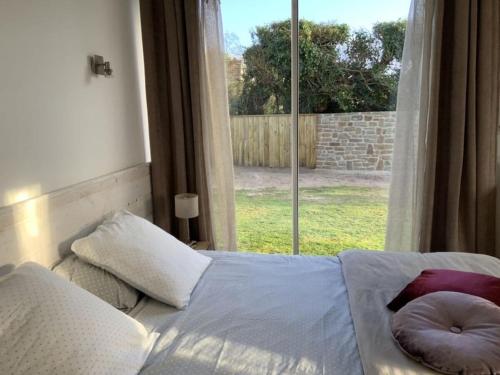 un lit dans une chambre avec une grande fenêtre dans l'établissement Holiday home Villa des Dune, à Cléder