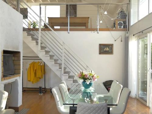 une salle à manger avec une table en verre et des escaliers blancs dans l'établissement Holiday home Villa des Dune, à Cléder