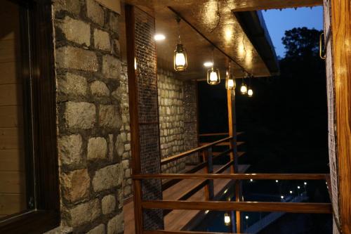 a balcony with lights and a brick wall at Sukoon Dk in Rudraprayāg