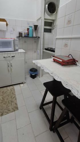 a kitchen with a table and a counter top at Apartamento no Centro - Condomínio Lido in Miguel Pereira