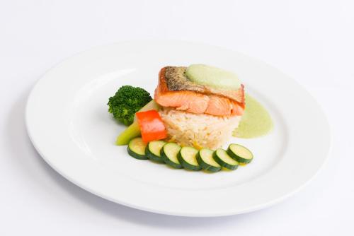 a plate of sushi and vegetables on a white plate at Distinction Whangarei Hotel & Conference Centre in Whangarei