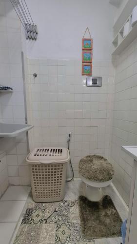 a bathroom with a toilet and a basket in it at Apartamento no Centro - Condomínio Lido in Miguel Pereira