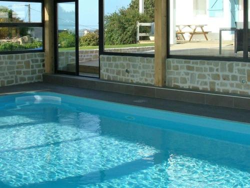 une piscine avec de l'eau bleue devant les fenêtres dans l'établissement Holiday home in Sibiril with swimming pool, à Sibiril