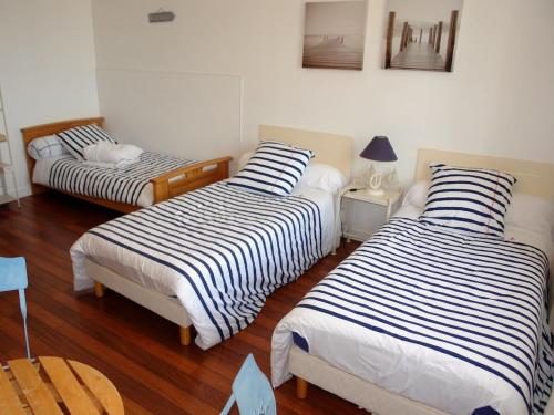 Cette chambre comprend 2 lits avec des draps rayés. dans l'établissement Holiday apartment with 2 bedrooms, à Sibiril