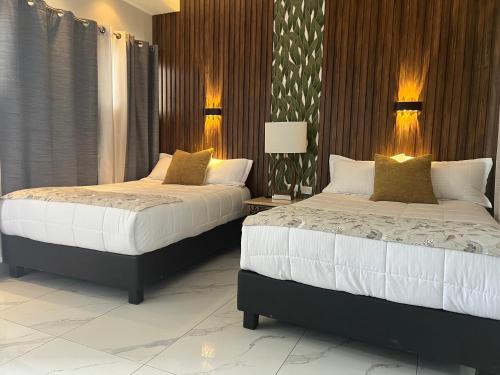 two beds in a bedroom with two lamps at DEPARTAMENTO CON TERRAZA Y VISTA para 6 personas in Chihuahua