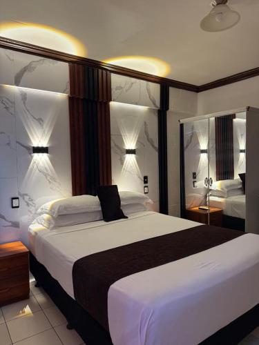 a bedroom with a large bed and two mirrors at Moatoga Hotel in Apia