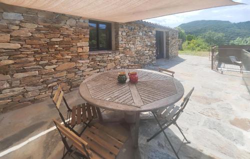 a wooden table and chairs on a patio at 3 Bedroom Stunning Home In Vieussan in Vieussan