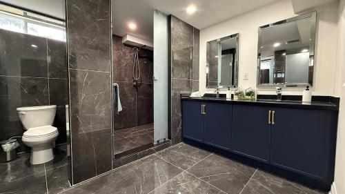 a bathroom with a toilet and a glass shower at 10 Br with Large Hot tubs 130 Proj Screen FirePit in Blue Mountains