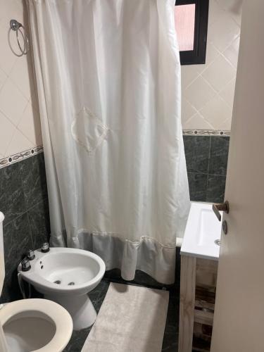 a bathroom with a toilet and a shower curtain at Rincón del mar in Mar del Plata