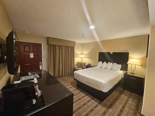 a hotel room with a bed and a desk at Best Western Pasadena Royale Inn & Suites in Pasadena