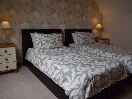 une chambre avec deux lits et deux tables de nuit dans l'établissement Holiday home with 3 bedrooms, à Neufmesnil