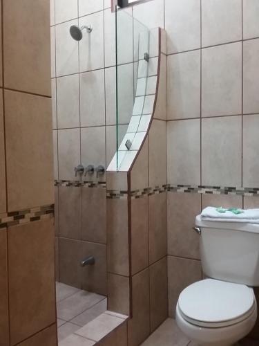 a bathroom with a shower with a toilet at Hotel Cibeles Resort in Heredia