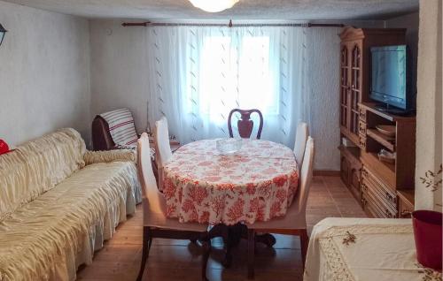 a dining room with a table and chairs and a television at Beautiful Home In Volarice -Sveti Juraj in Razbojište