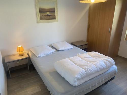 un lit avec deux oreillers dessus dans une chambre dans l'établissement Holiday home with 2 bedrooms, à Denneville-Plage