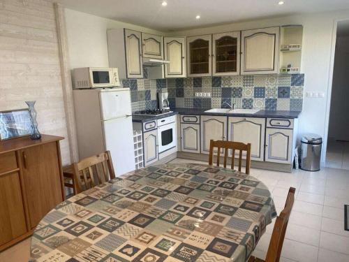 une cuisine avec une table et un réfrigérateur blanc dans l'établissement Holiday home with 2 bedrooms, à Denneville-Plage