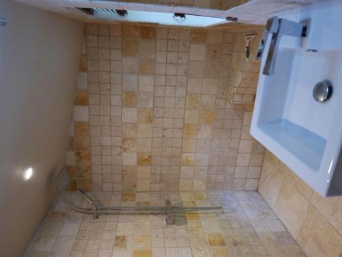 La salle de bains est pourvue d'une douche et de carrelage. dans l'établissement 1-bedroom holiday apartment, à Négreville