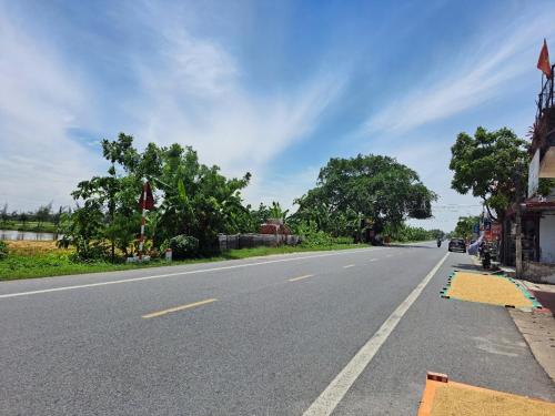 een lege weg met bomen aan de kant van de weg bij GolDen RiCe in Thái Thụy