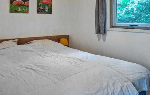 a white bed in a bedroom with a window at 2 Bedroom Lovely StaCaravan In Vorden in Vorden