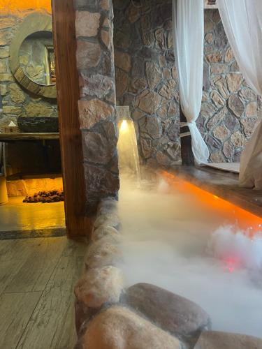 a room with a stone wall with steam coming out of it at 哲帆民宿百年风化老木屋 in Zengjia