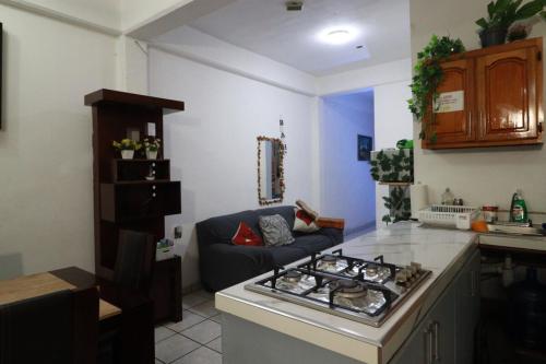 a kitchen with a stove and a couch in a room at Casa Tortuga - Excellent Location - Close to Beach in Lázaro Cárdenas