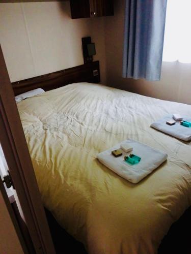 - un lit avec 2 serviettes et 2 bougies dans l'établissement Superbe Mobilehome 3 ch, climatisé tout confort, à Onesse-et-Laharie