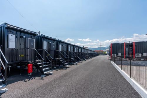a row of train cars parked on a road at HOTEL R9 The Yard Tomiokananokaichi in Tomioka
