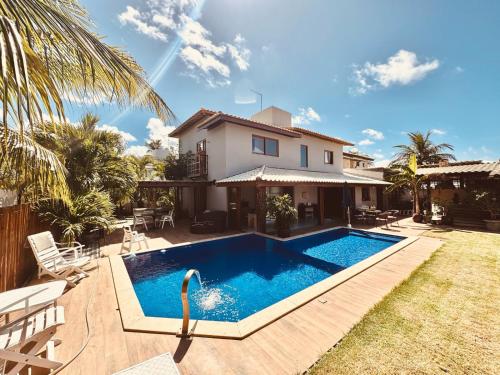 a villa with a swimming pool in front of a house at Casa proxima ao mar em Guarajuba in Avaré