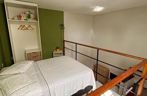 een slaapkamer met een bed en een trap met groene muren bij Loft Lampião in Campina Grande