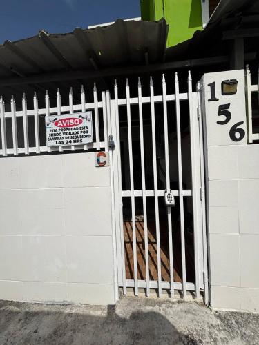 a white gate with a sign on it at Salo Casa Verde Studio in San Juan