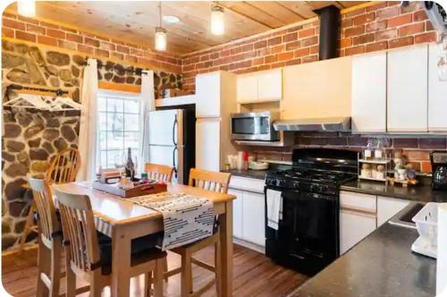 a kitchen with a wooden table and a stove top oven at Hidden Gem in Pocono Pines in Pocono Pines