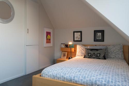 a bedroom with a bed with a blue comforter at Sunrise Serenity with Hot Tub in Christchurch