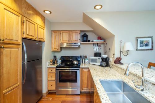 a kitchen with stainless steel appliances and wooden cabinets at Cimarron Lodge 35 condo in Telluride
