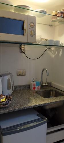 a kitchen counter with a sink and a microwave at Mía Apart in Buenos Aires