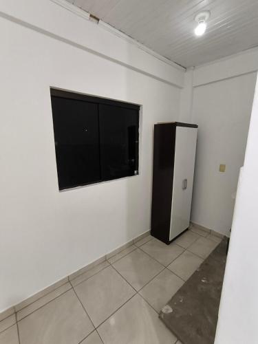 a white room with a black refrigerator and a window at Dpto a pasos de la playa San José in Encarnación
