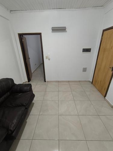 a living room with a couch and a door at Dpto a pasos de la playa San José in Encarnación